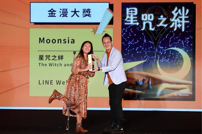 頒獎人李隆杰（右）頒發「金漫大獎」獎座予得獎者Moonsia（左），作品「星咒之絆」