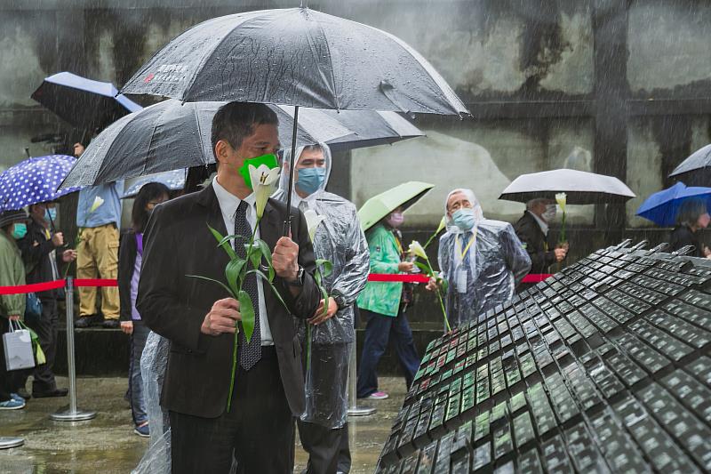 文化部長李永得與政治受難者、家屬們人手一支象徵人權與自由的鐵砲百合，繞行人權紀念碑追思。