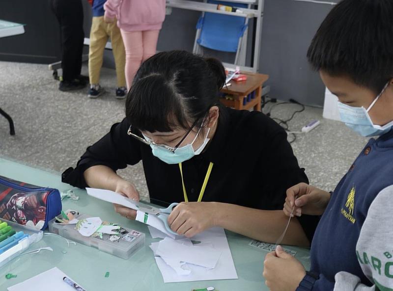 梁玉慧在營隊中協助學童製作紙偶