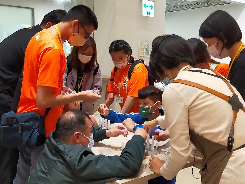 展場導覽員仔細講解操作步驟，讓服務對象與家人可以更快上手、享受手作蠟筆的樂趣。