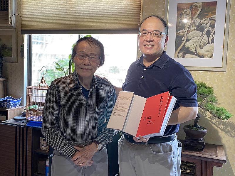 陳子福先生（左）於專書《繪聲繪影一時代：陳子福的手繪電影海報》簽名留念，並與國家影視聽中心董事長藍祖蔚（右）合影（國家影視聽中心提供）