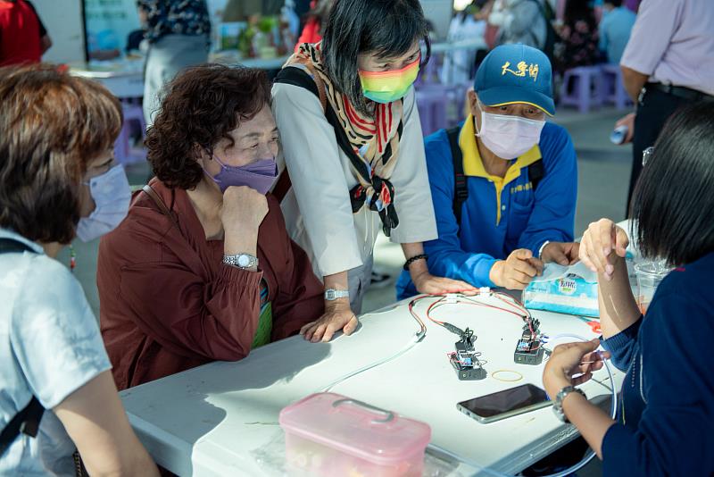 銀髮族闖關者認真聽關主講解「光的混搭，醬玩!」實驗。