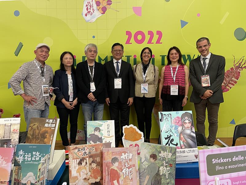 2022義大利盧卡國際漫畫節開幕首日，駐義副代表林讚南（中）偕文化組長鄧美容（左2）、漫畫節主辦單位Lucca_Crea_S.r.l公司主席法茲（Francesca_Fazzi，右3）、活動內容部主任里戈尼（Alberto_Rigoni，右1）等至臺灣展區為臺義漫畫交流共同見證，並為臺灣參展漫畫家鼓勵支持。