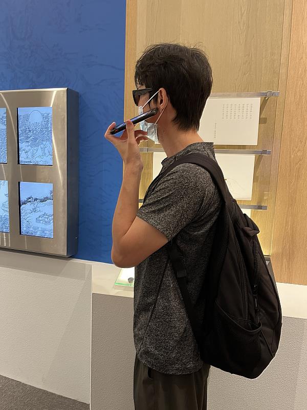 受試者於《臺灣八景詩》互動裝置前聆聽導覽介紹。