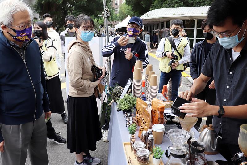 長庚大學湯明哲校長(左一)逛園遊會攤位，欣賞同學手沖咖啡。