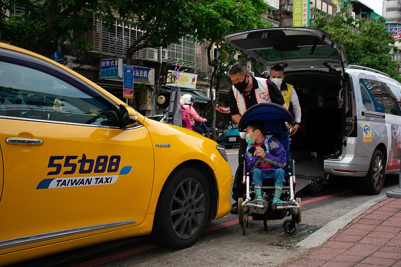 「台灣計程車駕駛暖心協會」也是這次活動的志工群之一，圖為志工推著特教生，未免撞到孩子小心避開車輛保險桿。(紅線停車處已申請活動路權)