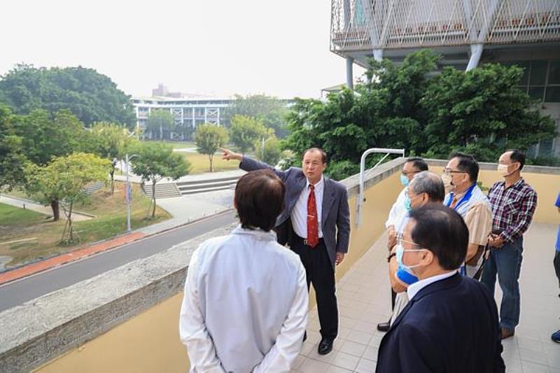 【南臺科大校長盧燈茂於校史館陽台向與會貴賓說明校園現況之情形】