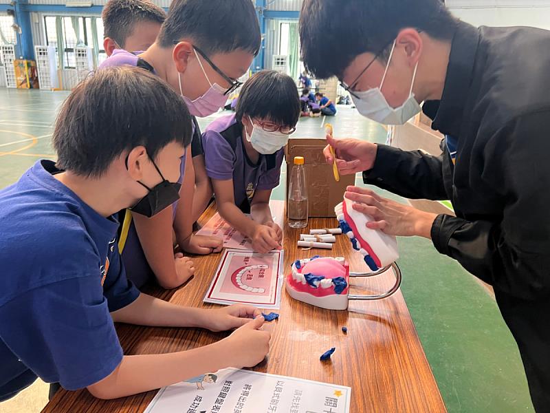 義守大學健管系學子，將口腔衛生衛教，以遊戲的互動讓國小學童更進一步學習正確的刷牙習慣(照片來源：義守大學提供)。