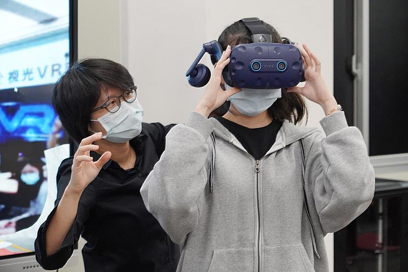 大葉大學視光系陳雅郁老師(左)協助學生穿戴VR裝置