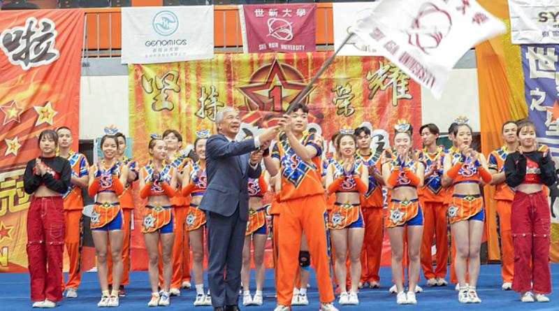 圖二：世新啦啦隊隊長李振安代表團隊接受校長陳清河授旗，展現奪冠決心