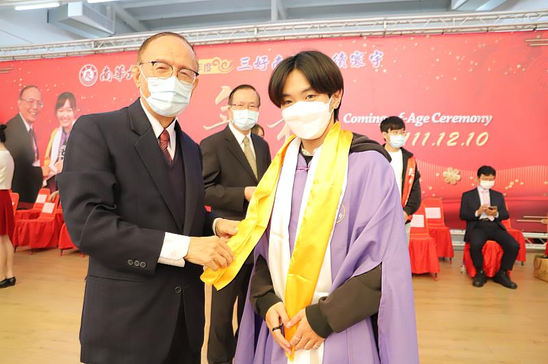 南華大學依循古禮舉辦成年禮，林聰明校長一一為學生披上象徵飛黃騰達的黃巾，行「再加禮」儀式。