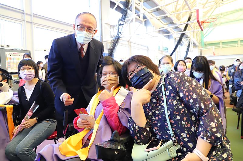 南華大學依循古禮舉辦成年禮，林聰明校長為應社系特教生許庭瑜同學(中)披上象徵飛黃騰達的黃巾，行「再加禮」儀式。右為許同學的母親。