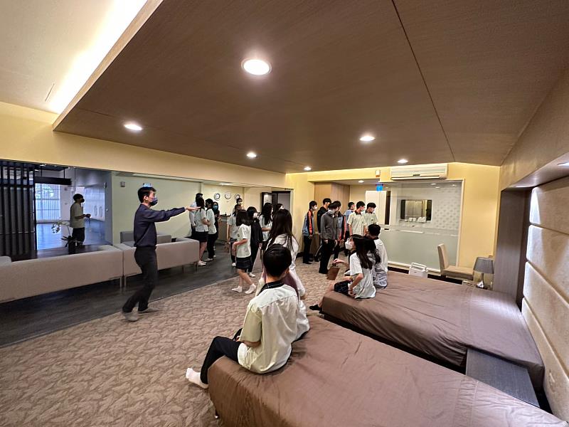 吳國龍主任向學生介紹飯店櫃台與房間設施
