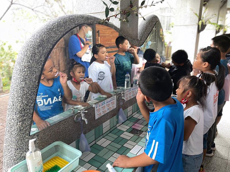 健管系學生利用午餐時間，教導學童正確刷牙的方式，小學生認真學習、立即驗收(照片來源：義守大學提供)。