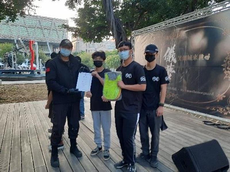 海軍儀隊郭中士於南臺科技大學軍儀隊期末社團成果發表暨空軍儀隊交流活動中頒發獎狀與獎品之情形。