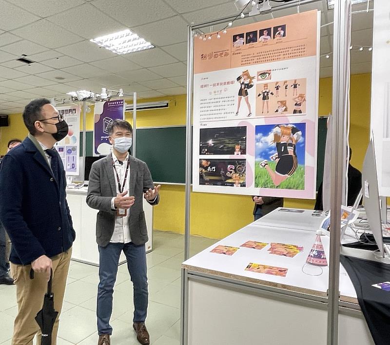 多媒體設計系提供設備及空間讓同學展示專題作品，謝安執行長（左）仔細欣賞學生的作品。