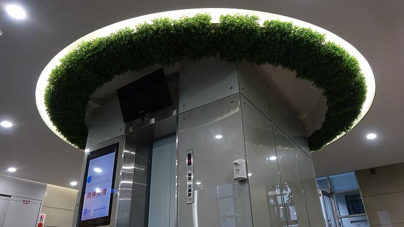 綺華建設捐贈臺科大管理大樓電梯上方環狀綠色擬真植栽