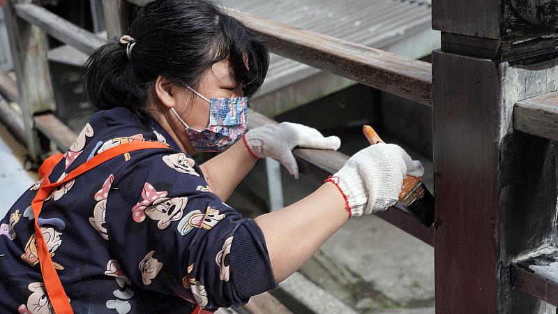 家園住民小珊一起粉刷欄杆，為家園妝點新裝
