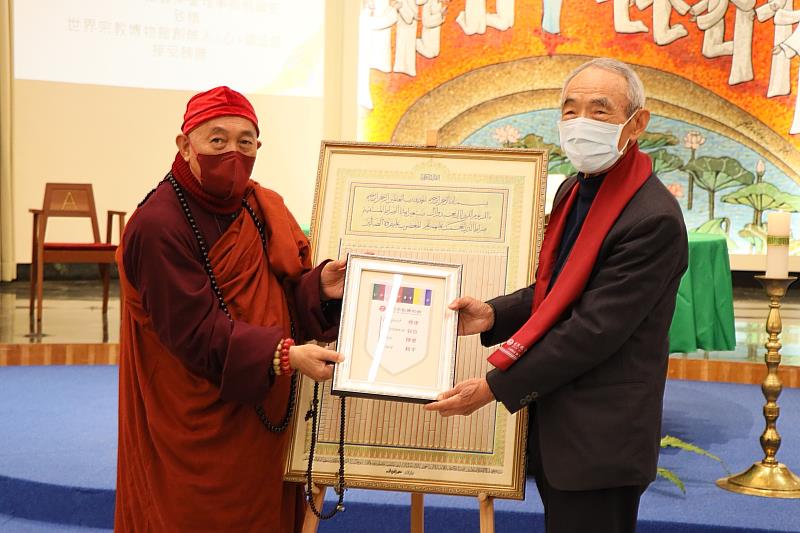 靈鷲山開山住持、世界宗教博物館創辦人心道法師（左），回贈世界宗教博物館錦旗給中國回教協會榮譽理事長倪國安（右），展現跨宗教的情誼。（圖由世界宗教博物館提供）