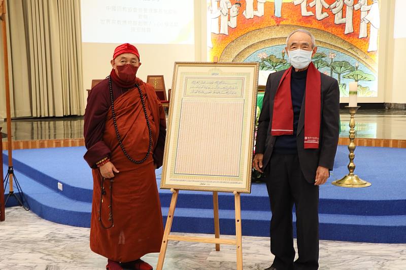 中國回教協會榮譽理事長倪國安（右）將一頁式《古蘭經》捐給世界宗教博物館，由創辦人心道法師（左）接受。（圖由世界宗教博物館提供）