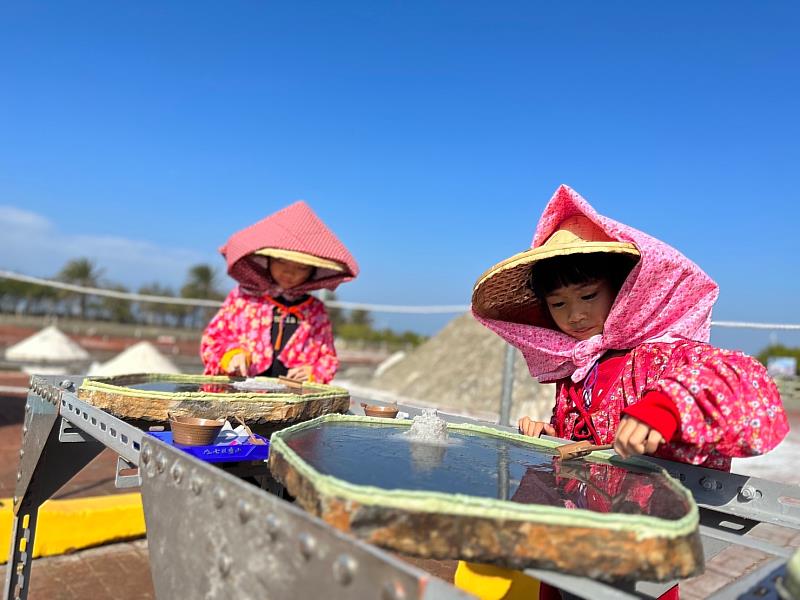 七股鹽山「石板天日曬鹽體驗」，女童著袖套、斗笠，化身最Q小鹽工。