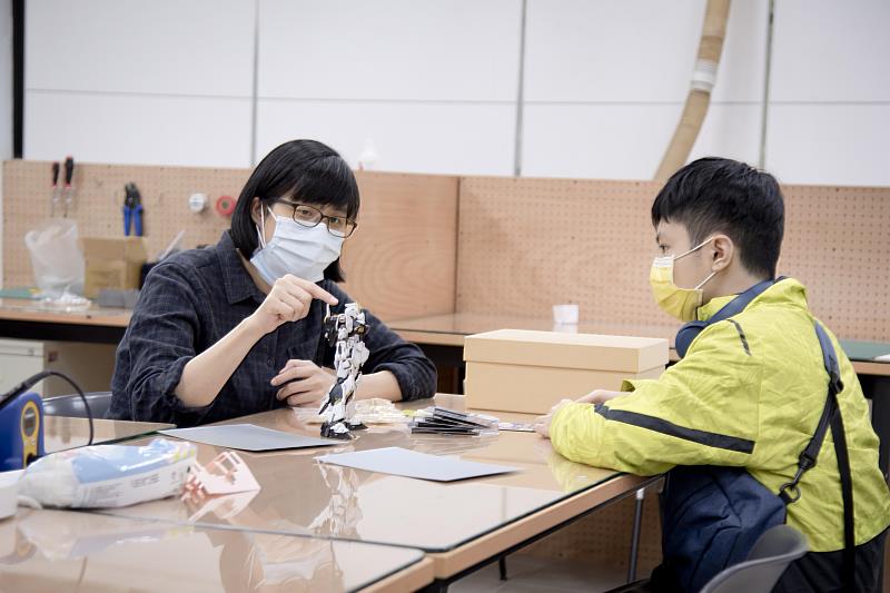 華梵大學自主學習學生陳家驊（右）在個人工作空間與老師討論機器人作品。