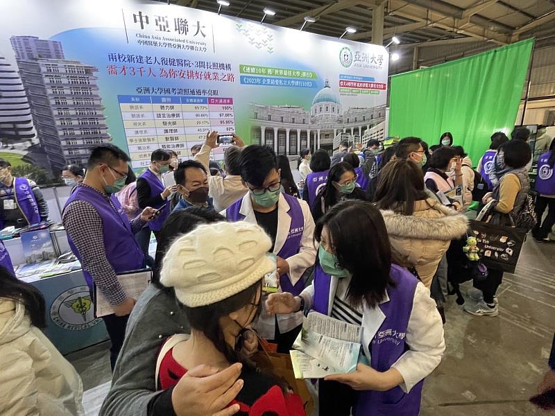 亞大在大學博覽會攤位前擠滿人潮，師生為考生解說、輔導選填志願。