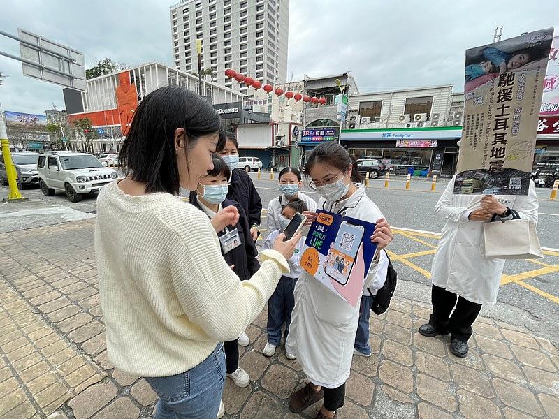 民眾在路邊也細心看說明，加入慈濟LINE群組。