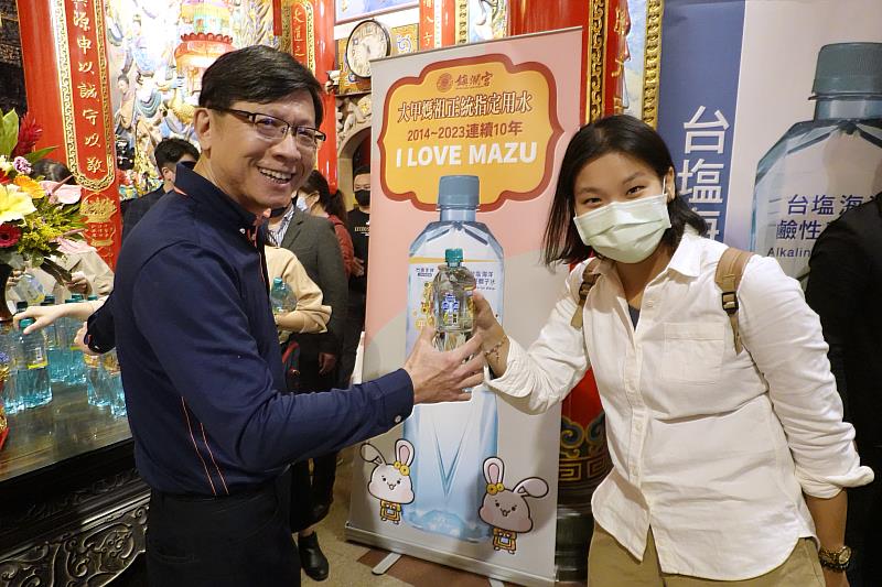 臺鹽公司總經理陳世輝（左）與信眾分享限量大甲媽聯名祈福瓶「台塩海洋鹼性離子水」，現場索取人潮踴躍。