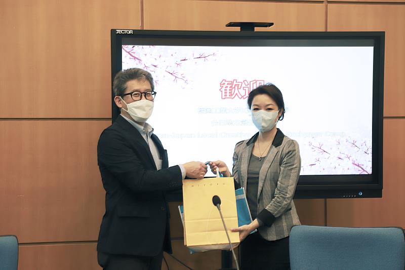 福岡工業大學社會環境學部部長藤井洋次教授(圖左)致贈紀念品，由高科大應日系主任洪心怡(圖右)代表接受。