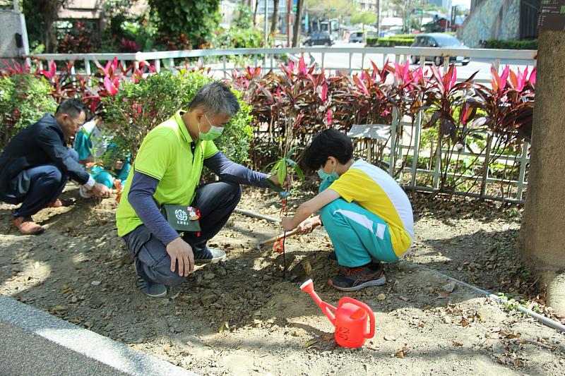 陳宇華理事(前綠色上衣)，大理國小家長會蔡天昇(後 丈青西裝)一起與小朋友植樹