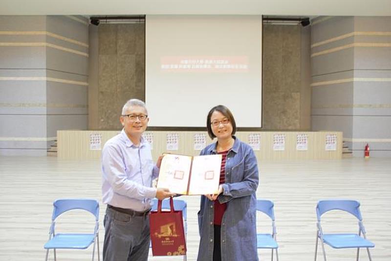 南臺科技大學通識教育中心主任薛清江(左)於通識大師講座特致贈聘書及紀念品予呂毅新團長暨藝術總監(右)。