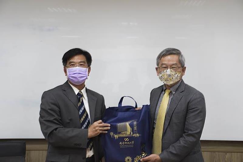 南臺科技大學校長吳誠文(右)與大榮高中校長張簡助立(左)互贈紀念品之情形。
