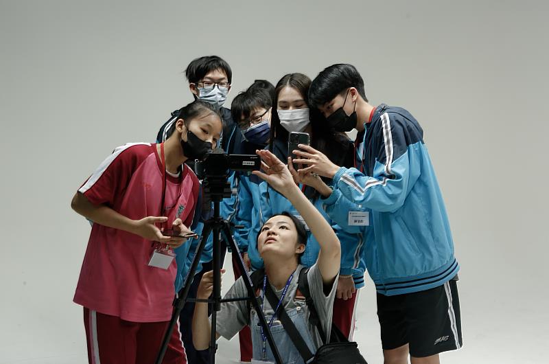 海星高中學生於小隊輔巫妤璇學姊指導下專注練習拍攝。