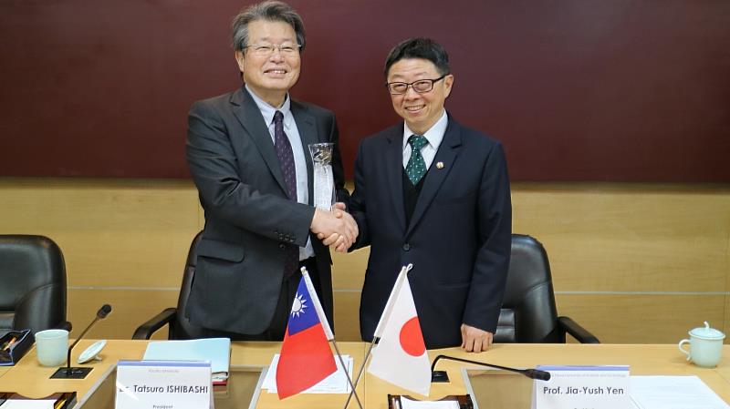 112年3月30日日本九州大學校長石橋達朗（左）率團回訪臺科大，臺科大校長顏家鈺（右）贈送本校設計系校友創業商品做為紀念禮品。