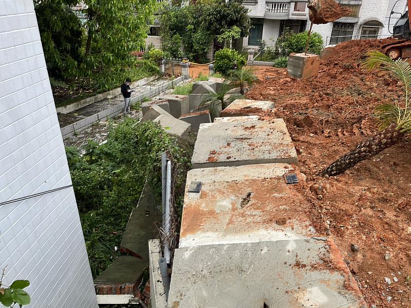 崩塌處土地的行為人未經申請堆積回填土石，及施作無擋土牆功能的混泥土塊構造物，經昨日強降雨造成土石崩塌，土石流入下邊坡社區庭院