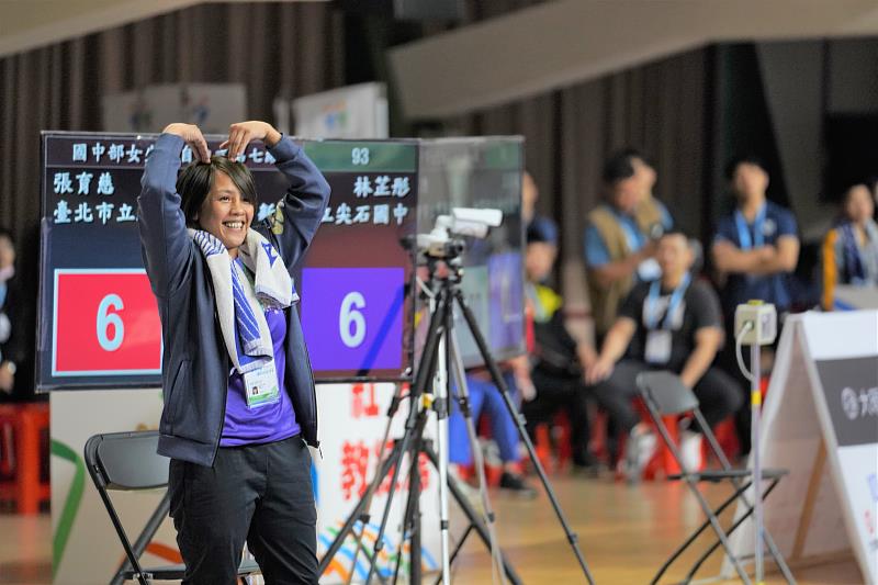 尖石國中柔道隊教練胡夏芬獲知比賽結果，立即在場邊對林芷彤比了一個大愛心
