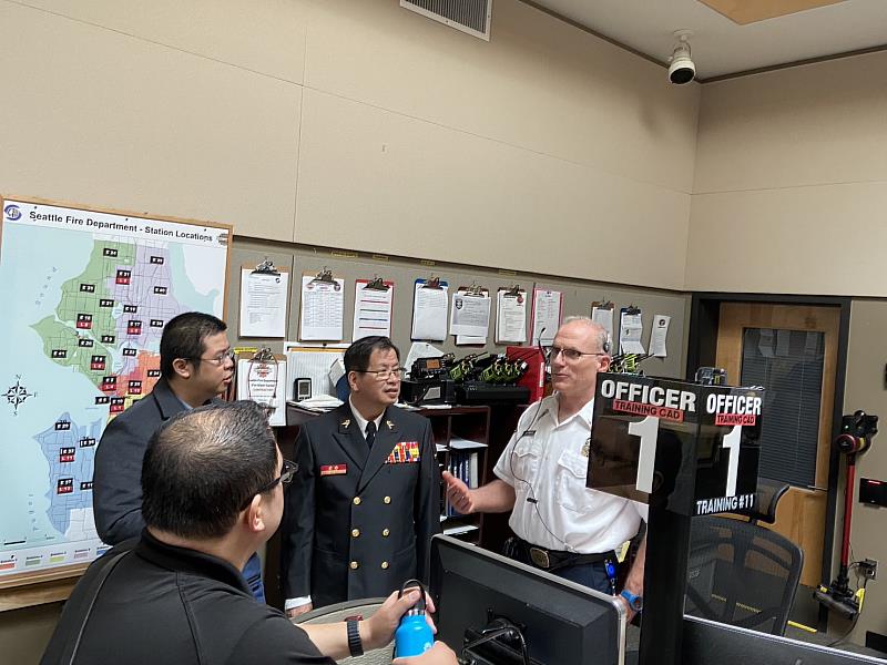 陳副局長崇岳與火災報案中心執勤官梅狄可熱烈討論勤務派遣內容。