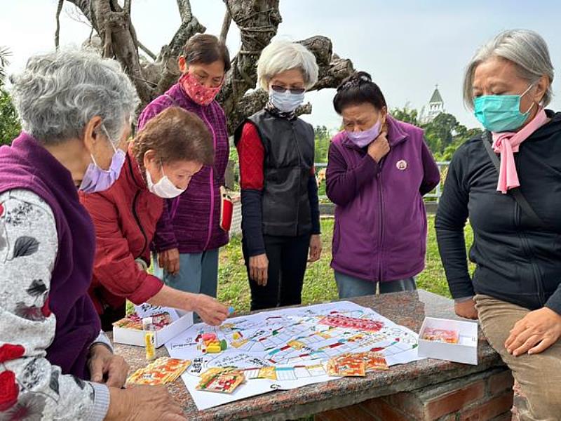 南臺科技大學《點亮左鎮相放伴—創意生活加值計畫》以創意生活設計方法活化左鎮風土資源，社區長輩試玩「夢迴老街大冒險」桌遊之情形。