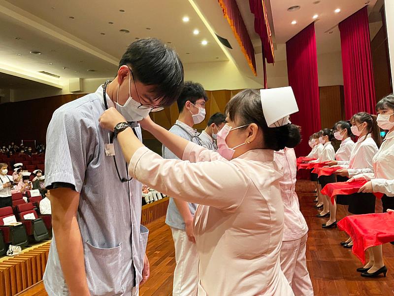 師長親手為學生們戴上護師帽及聽診器,代表學生將從課堂邁向醫院實習,鼓勵學生加冠後要更努力於專業知能培養,成為優秀護理師(照片來源:義守大學提供)。