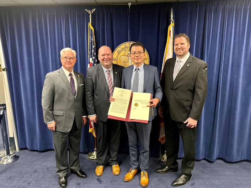 王處長到場接受決議文，與參議會代議長Greg J. Reed(左一)、提案人州參議員Andrew Jones(左二)及州眾議員Corey Harbison(右一)合影