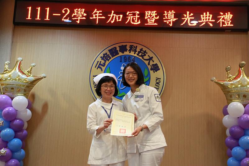 元培護理系學生黃議賢(右)從醫護學院鍾玉珠院長手中接下獲優良實習生獎。