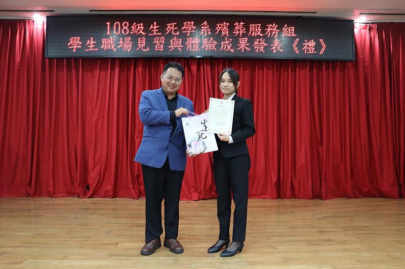 南華大學生死學系殯葬組學生陳妍欣(右)在實習期間表現優異，楊國柱主任(左)頒發「服務榮譽獎」。