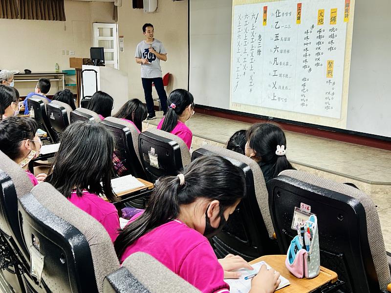 「淡水南北軒」總幹事翁瑋鴻為學童講解北管工尺譜及鑼鼓詩，認識傳統「Do、Re、Mi」