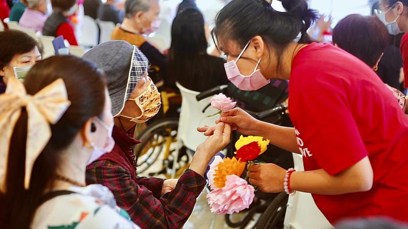 樂齡福祉與健康促進系師生，透過音樂與律動陪伴長輩，獻上一朵康乃馨，讓長輩覺得窩心。