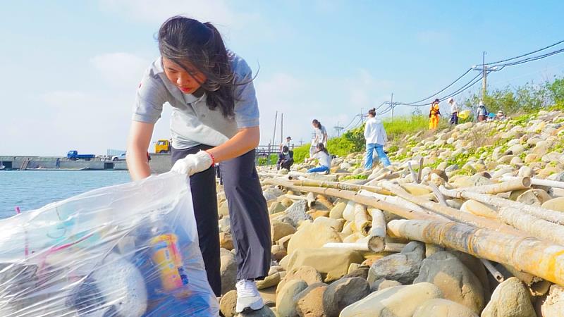 百餘名淨灘學生沿堤岸撿拾垃圾