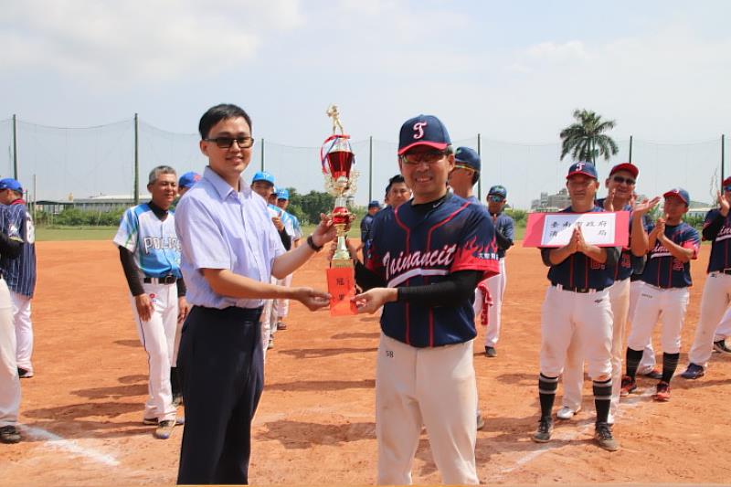 愛爾麗醫療集團秘書曾紀菱頒發冠軍獎座和獎金給獲得冠軍的台南市消防局