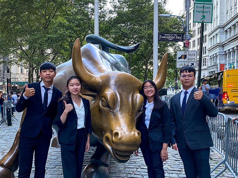 余昱錡(左2)與同學至曼哈頓下城金融中心的華爾街參觀，與鎮街之寶「銅牛」合影