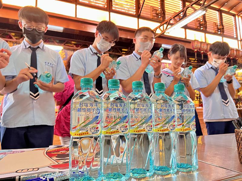 家齊高中考生們在「金榜題名版」台塩海洋鹼性離子水瓶標上，填上第一志願，盼能錄取心中理想學校。