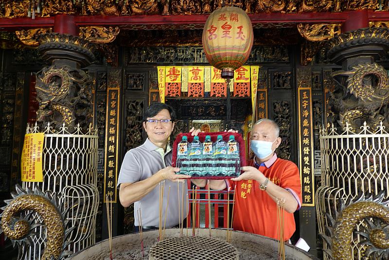 臺鹽公司總經理陳世輝(左)與開基玉皇宮副主委王飳乾(右)，共同將「金榜題名版」台塩海洋鹼性離子水過爐，為考生祈福。